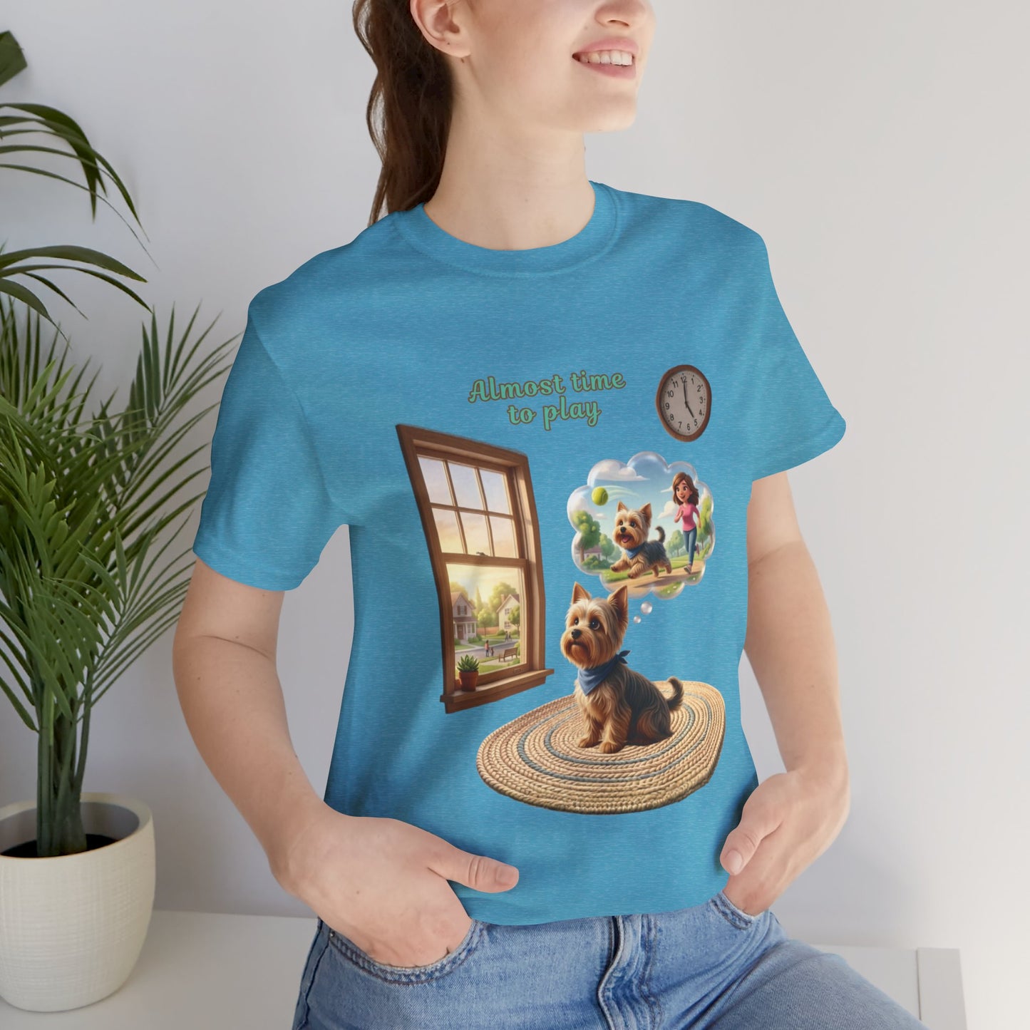 Person wearing a blue t-shirt with a dog graphic and text, standing indoors.