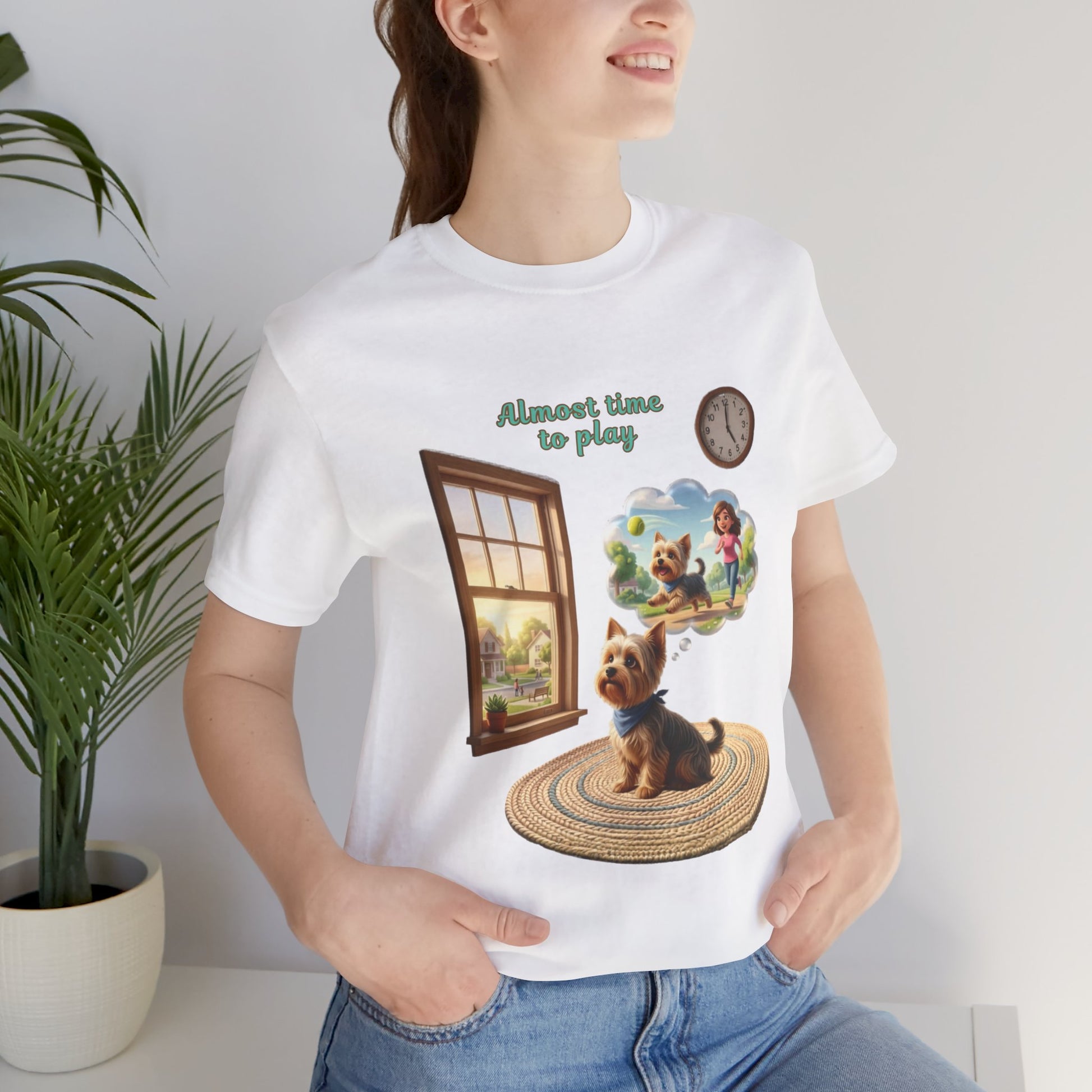 Person wearing a white t-shirt with a dog graphic and text, standing indoors.