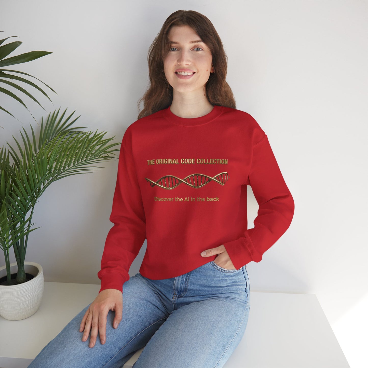 Person wearing a red sweatshirt with text, sitting on a white surface with a plant in the background.
