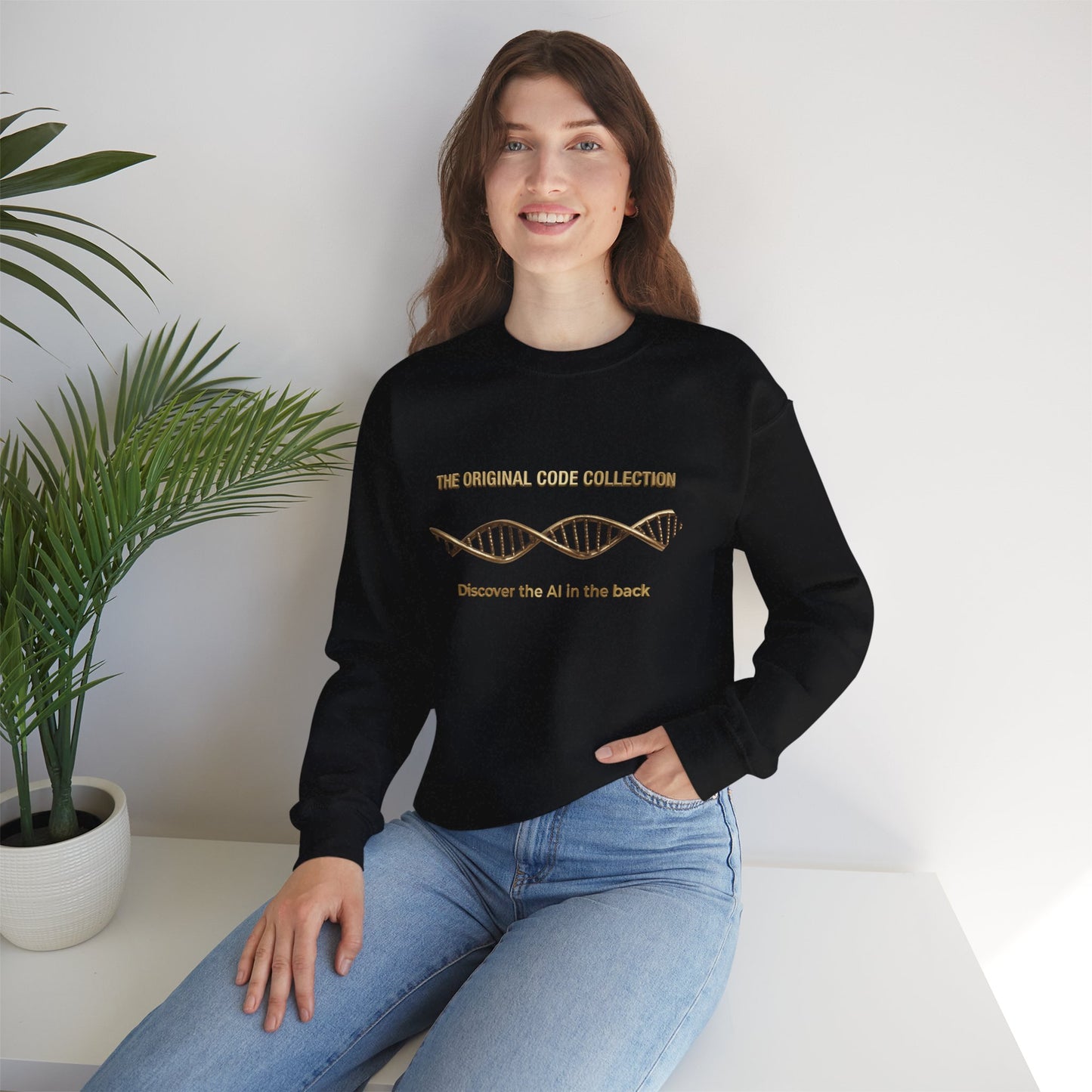 Woman wearing a black sweater and blue jeans sitting on a white surface with a plant in the background.