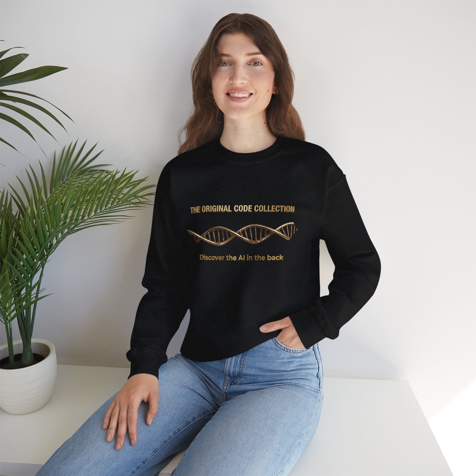 Woman wearing a black sweater and blue jeans sitting on a white surface with a plant in the background.